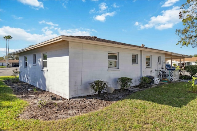 view of side of home with a yard and cooling unit