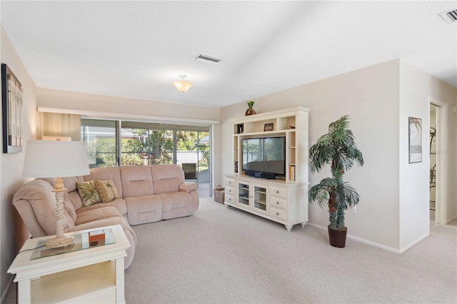 carpeted living room with visible vents and baseboards