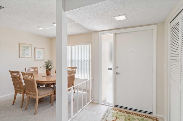 dining area featuring light tile patterned floors, visible vents, baseboards, and a textured ceiling