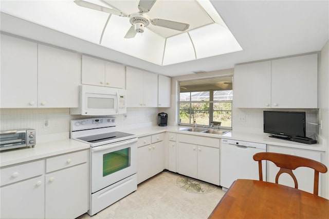 kitchen with white appliances, light countertops, tasteful backsplash, and a sink