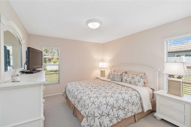 bedroom with baseboards and light colored carpet