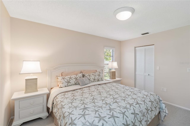 bedroom featuring visible vents, baseboards, carpet, and a closet