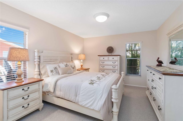 bedroom featuring baseboards and light colored carpet