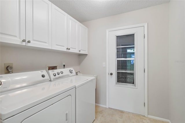 clothes washing area with baseboards, light tile patterned floors, cabinet space, a textured ceiling, and independent washer and dryer