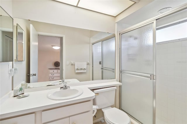 full bathroom featuring vanity, a shower stall, and toilet