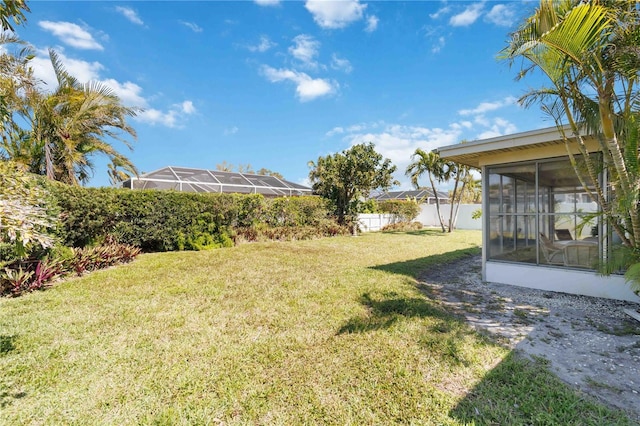 view of yard featuring fence and a sunroom