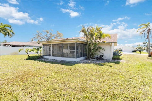 back of house featuring a yard, a sunroom, and fence