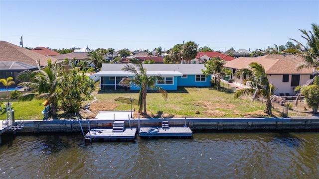 rear view of house featuring a yard, a water view, and a residential view