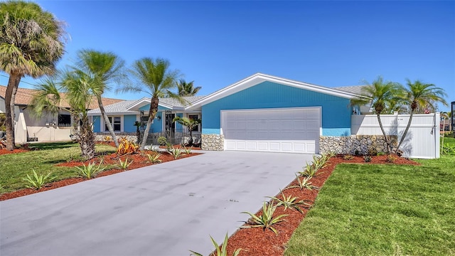 ranch-style house with stucco siding, fence, concrete driveway, a front yard, and a garage