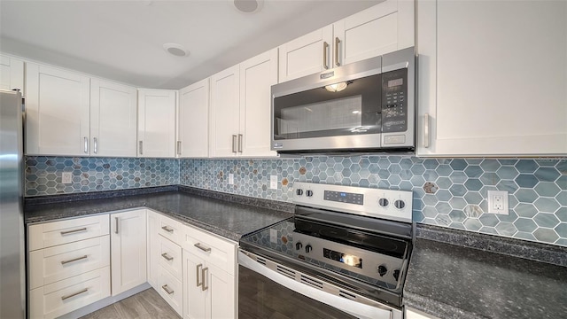 kitchen featuring decorative backsplash, white cabinets, and stainless steel appliances