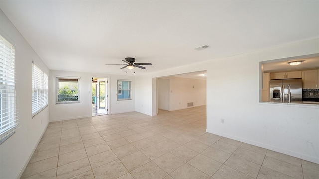 spare room with light tile patterned floors, visible vents, baseboards, and ceiling fan