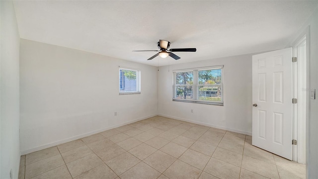 spare room with light tile patterned flooring, ceiling fan, and baseboards