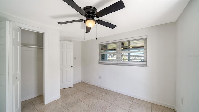 unfurnished bedroom with light tile patterned floors, a closet, baseboards, and ceiling fan