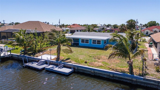 back of property with a yard, a water view, and a residential view