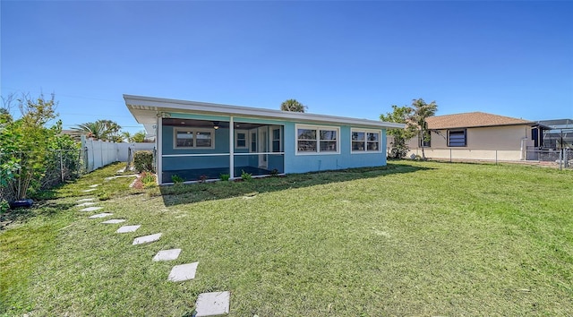 view of front of house featuring ceiling fan, a front yard, stucco siding, a fenced backyard, and a sunroom