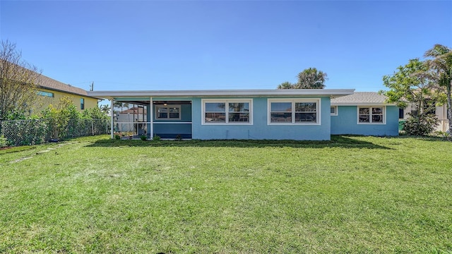 ranch-style home featuring stucco siding, a front lawn, and fence