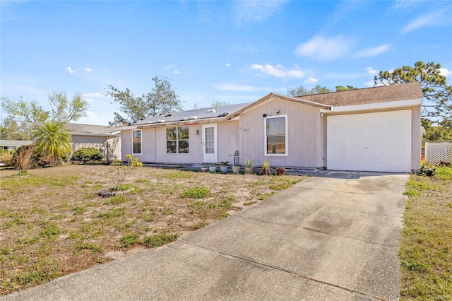 ranch-style house with concrete driveway and an attached garage