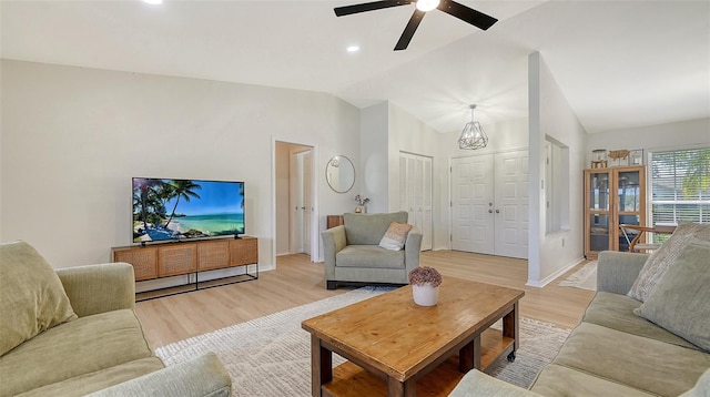 living area with light wood-type flooring, vaulted ceiling, baseboards, and ceiling fan