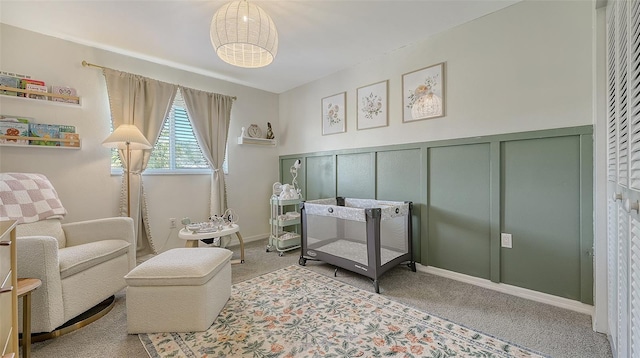 interior space featuring a wainscoted wall, carpet, and a decorative wall