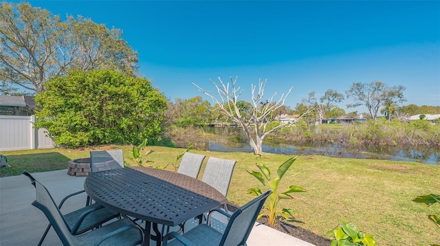 view of patio with outdoor dining area, a water view, and fence