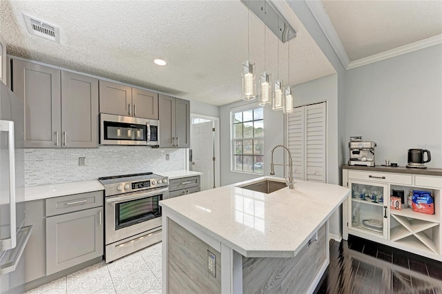 kitchen with a sink, stainless steel appliances, gray cabinets, and visible vents