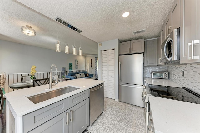 kitchen featuring appliances with stainless steel finishes, gray cabinets, and light countertops