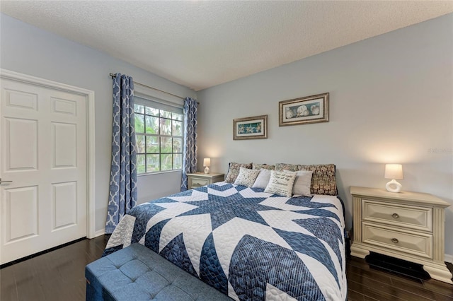 bedroom featuring dark wood-style floors and a textured ceiling