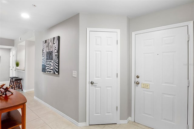 hallway with light tile patterned floors and baseboards