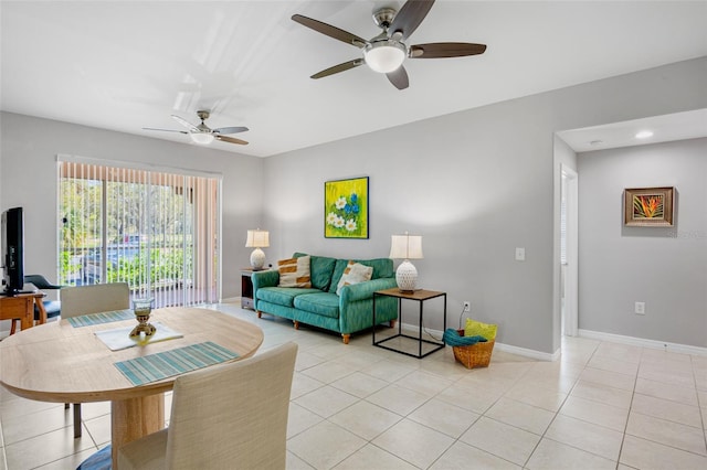 living room with light tile patterned floors, a ceiling fan, and baseboards