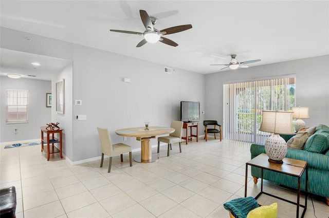 living area featuring visible vents, plenty of natural light, baseboards, and light tile patterned flooring