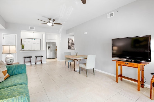 living area featuring light tile patterned floors, visible vents, and ceiling fan