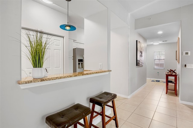 interior space featuring light tile patterned floors and baseboards