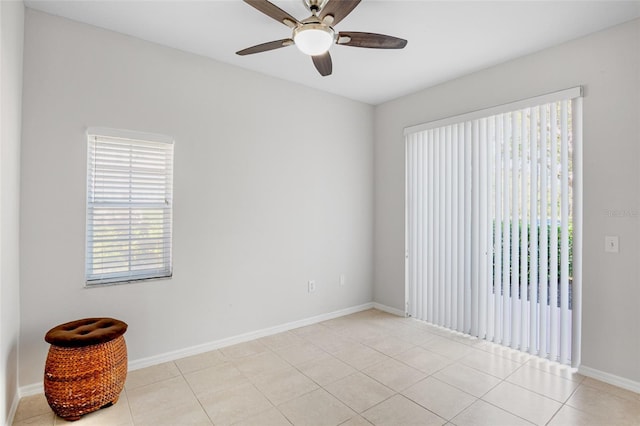 spare room with light tile patterned flooring, ceiling fan, and baseboards