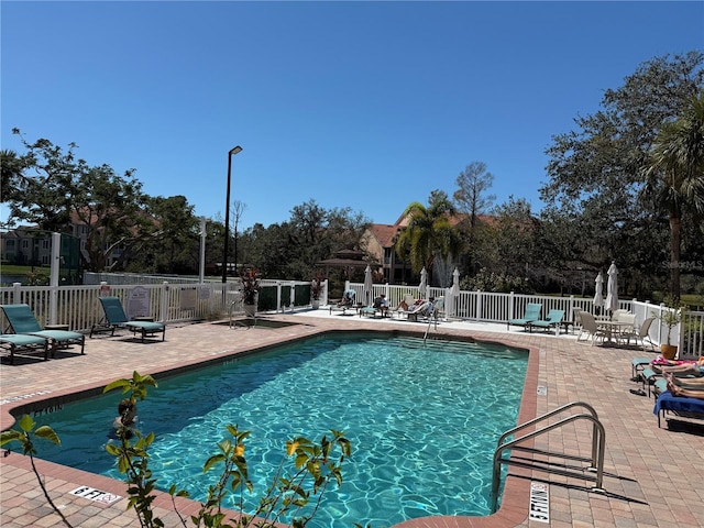 pool with a patio and fence