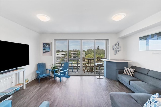 living area with baseboards and wood finished floors