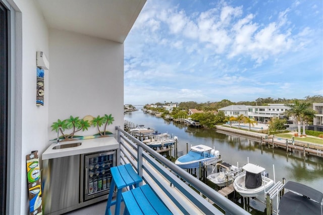 balcony with a boat dock, a water view, and boat lift