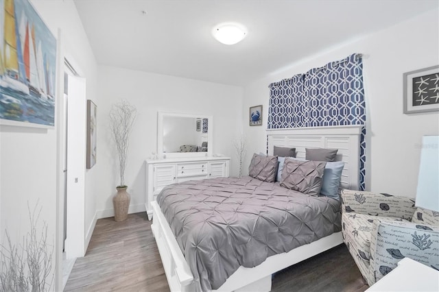 bedroom featuring baseboards and wood finished floors