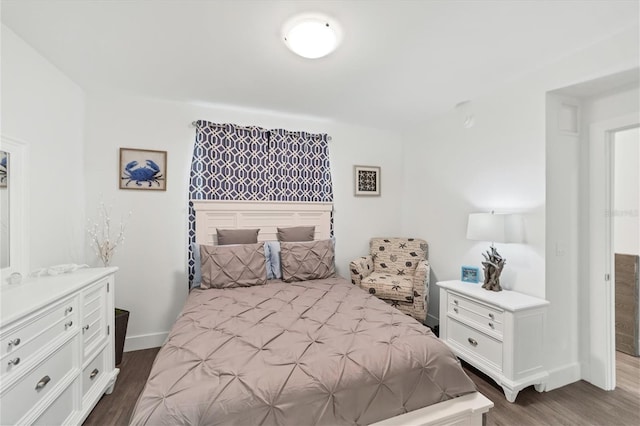 bedroom with wood finished floors and baseboards