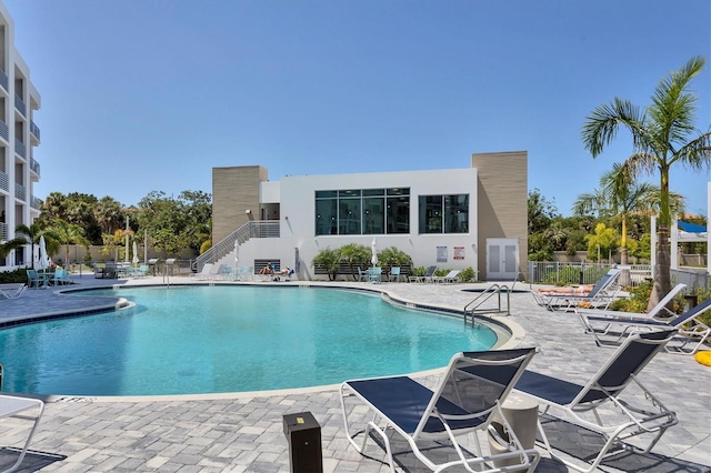 community pool with a patio and fence