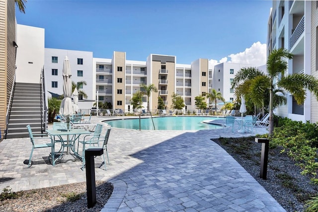 community pool with a patio area and stairway