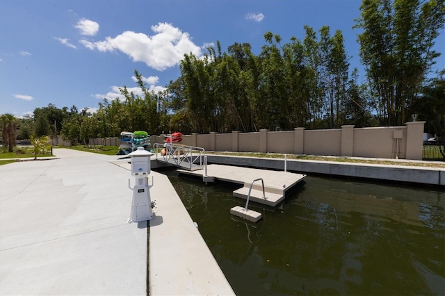 view of dock featuring a water view and fence