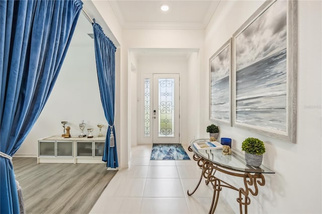 entryway with wood finished floors and crown molding