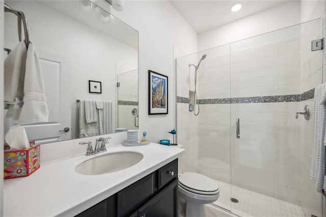 bathroom featuring a stall shower, vanity, and toilet