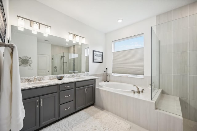 full bath with double vanity, a stall shower, a garden tub, and a sink