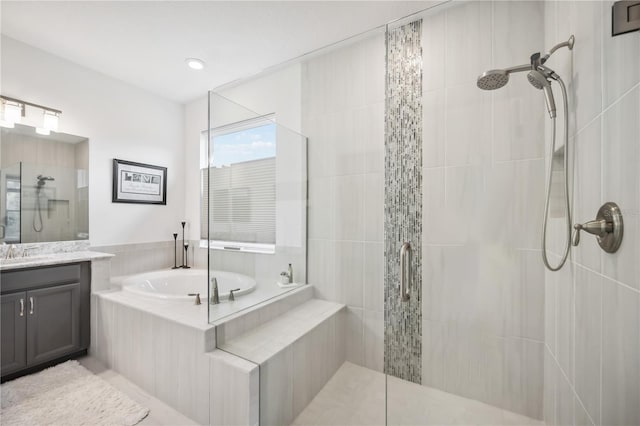 bathroom featuring a garden tub, a shower stall, and vanity