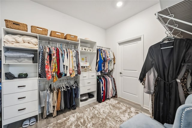 walk in closet with light wood-style floors