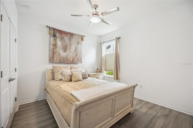 bedroom with dark wood-style flooring, a ceiling fan, and baseboards