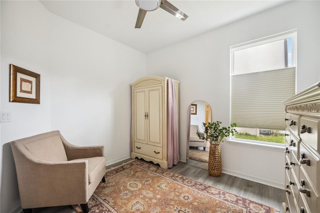 sitting room with ceiling fan, baseboards, and wood finished floors