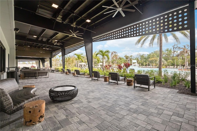 view of patio with a ceiling fan and a water view