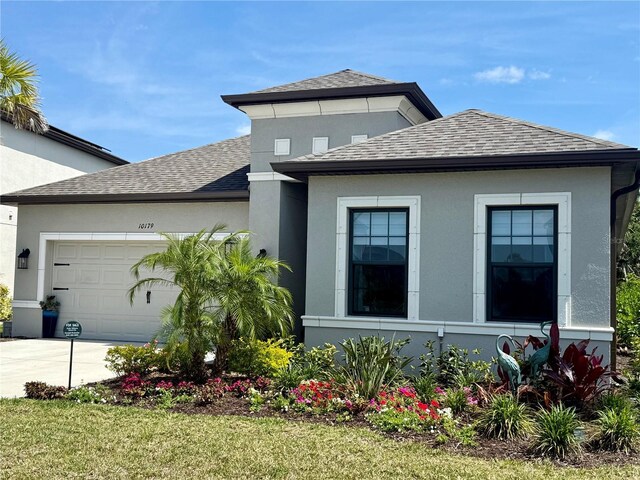 10179 Milky Way Cir, Sarasota, FL 34241 - view of front of home with concrete driveway, stucco siding, a shingled roof, and a garage
